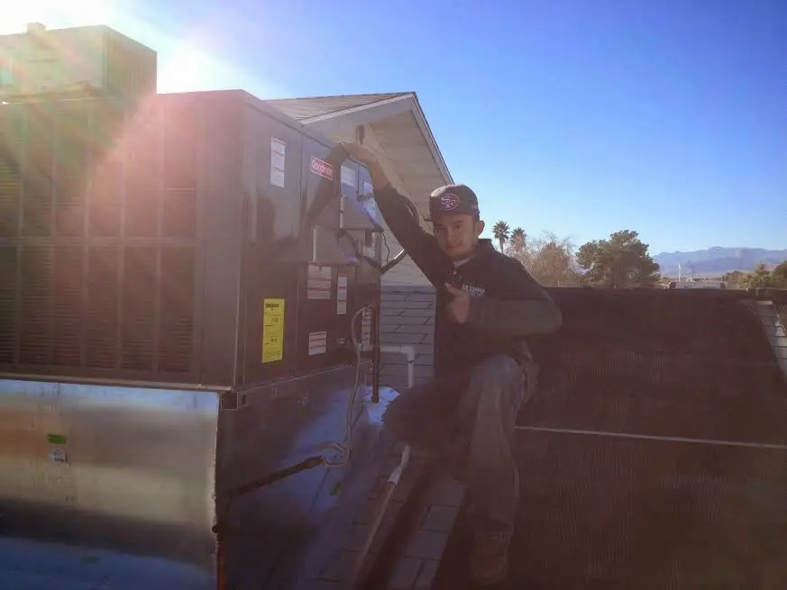 HVAC technician performing Heat Pump Repair on a rooftop unit in Glencoe